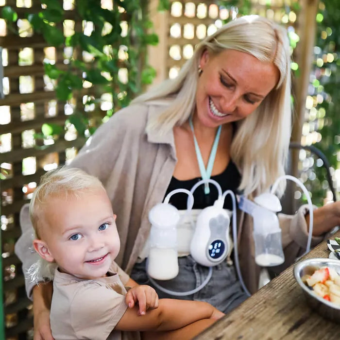 Woman with breast pump and baby.