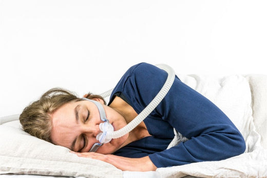 A woman sleeping on her side while wearing a CPAP mask