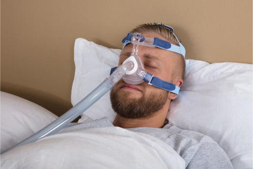A man using a CPAP mask while he sleeps