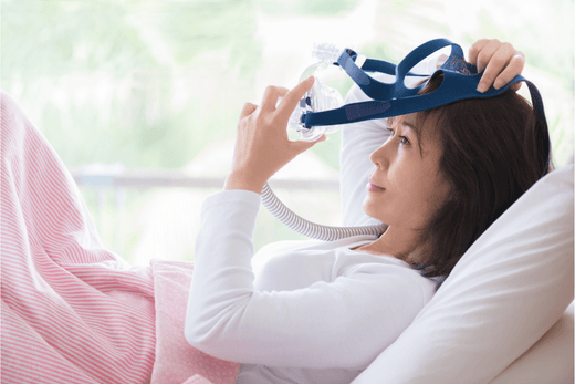 A woman putting on her CPAP mask