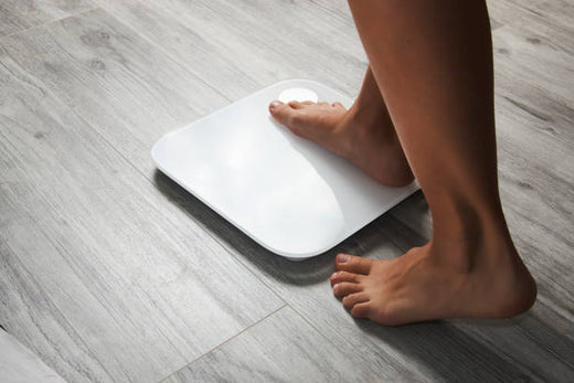 Woman stepping on weight scale