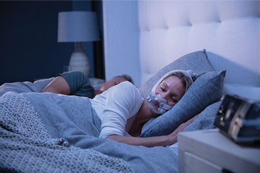 Woman sleeping while using a CPAP mask