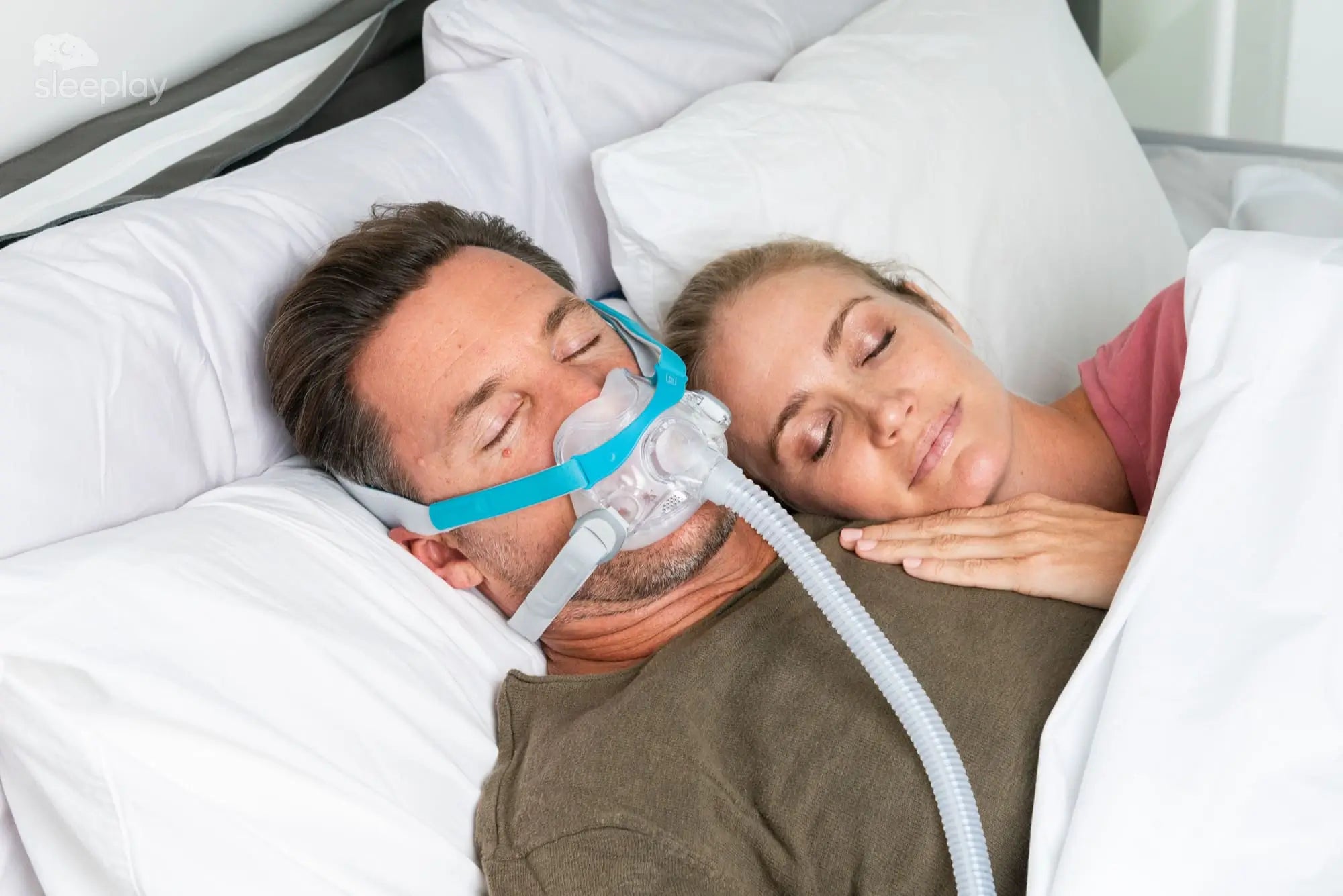 couple sleeping while a man is using the Evora Full Face CPAP mask for sleep apnea