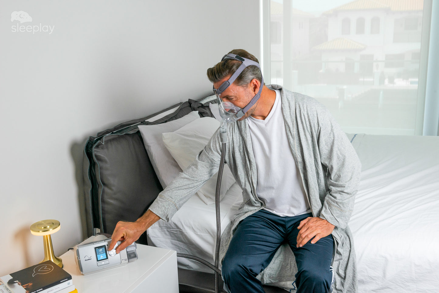 Man adjusting machine while wearing Simplus CPAP mask.
