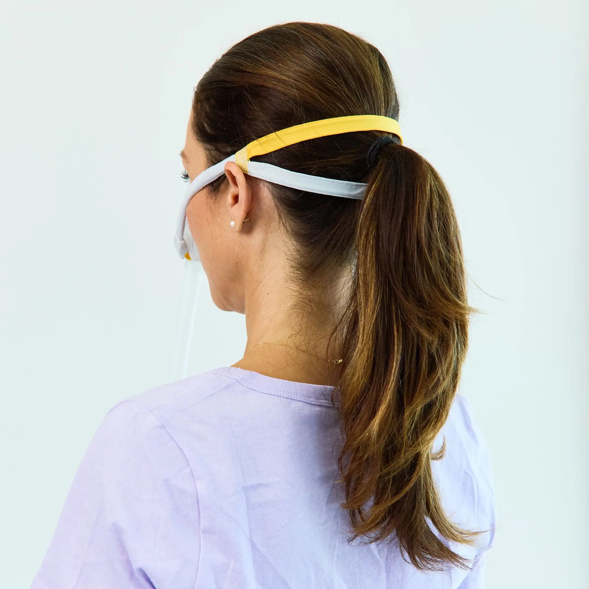 Back view of a woman using the solo nasal mask for CPAP.