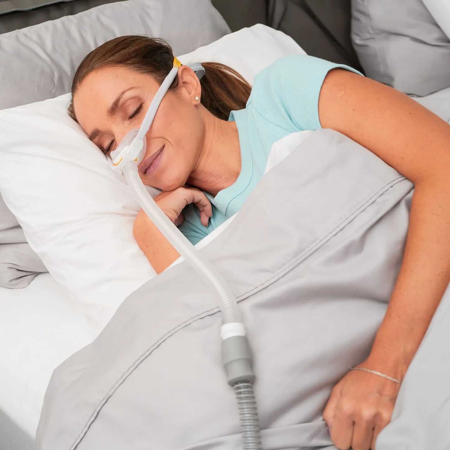 Woman sleeping using the solo nasal mask for CPAP.