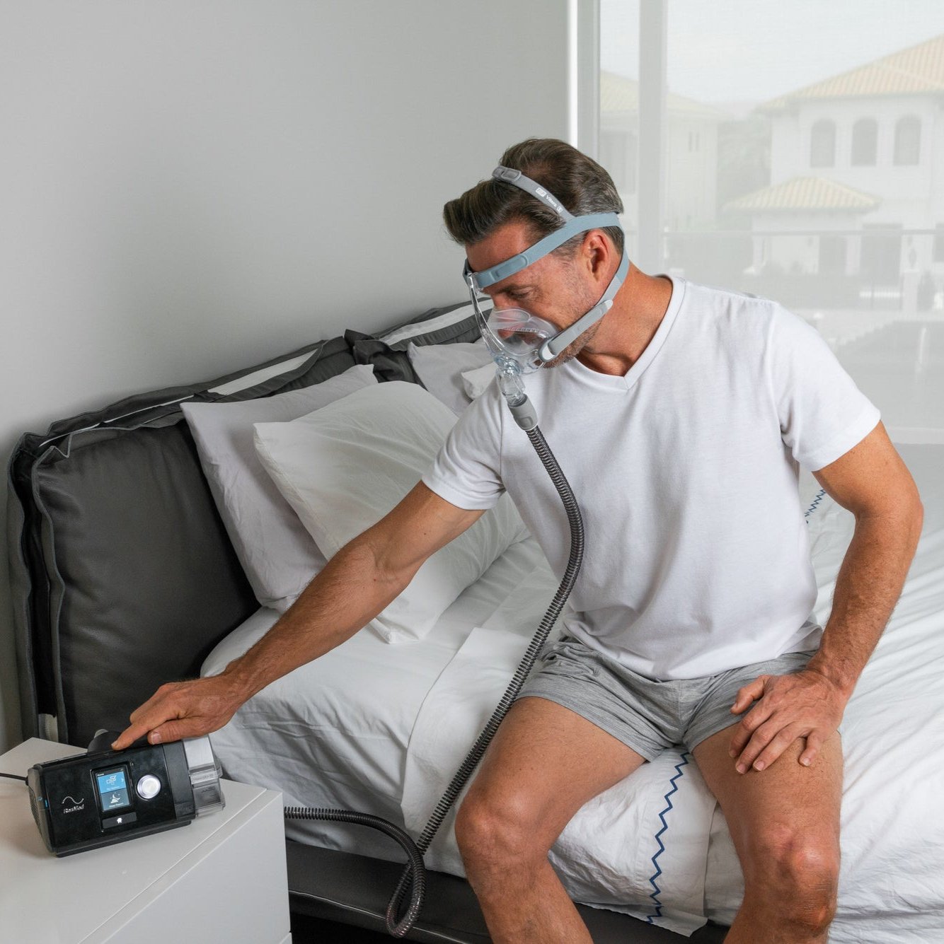 Man adjusting CPAP machine wearing the Vitera CPAP mask.