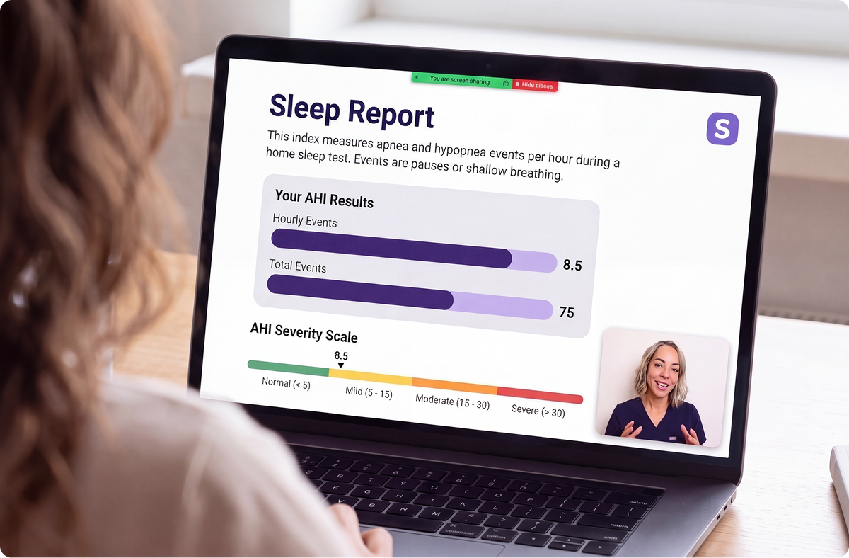 A person seated at a desk uses a laptop showing a Sleep Report dashboard with bar graphs and a small video call window. The scene is photographed in a real indoor environment with a blurred background.