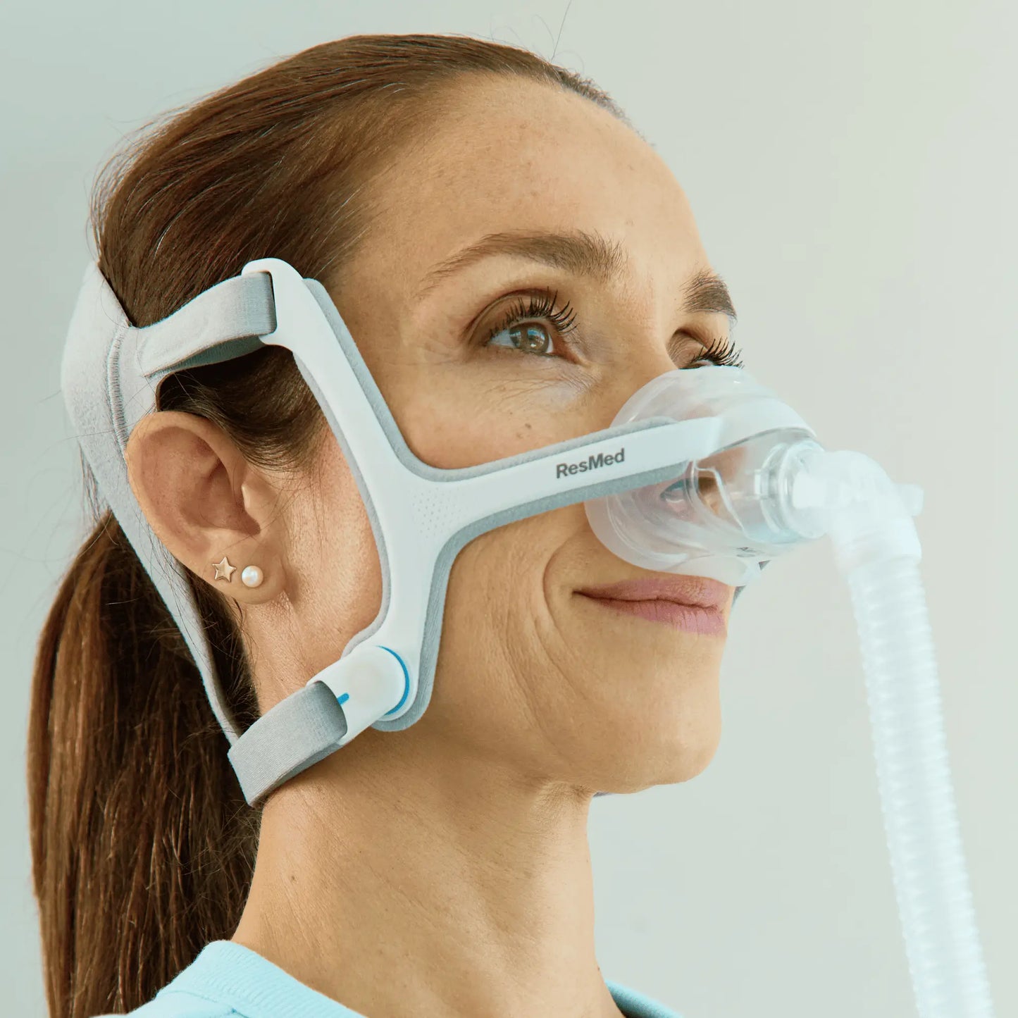 Lower view of a woman using a ResMed AirFit™ N20 for Her Nasal CPAP Mask with Headgear