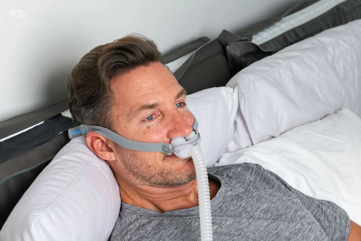 Men in bed using AirFit P10 CPAP.