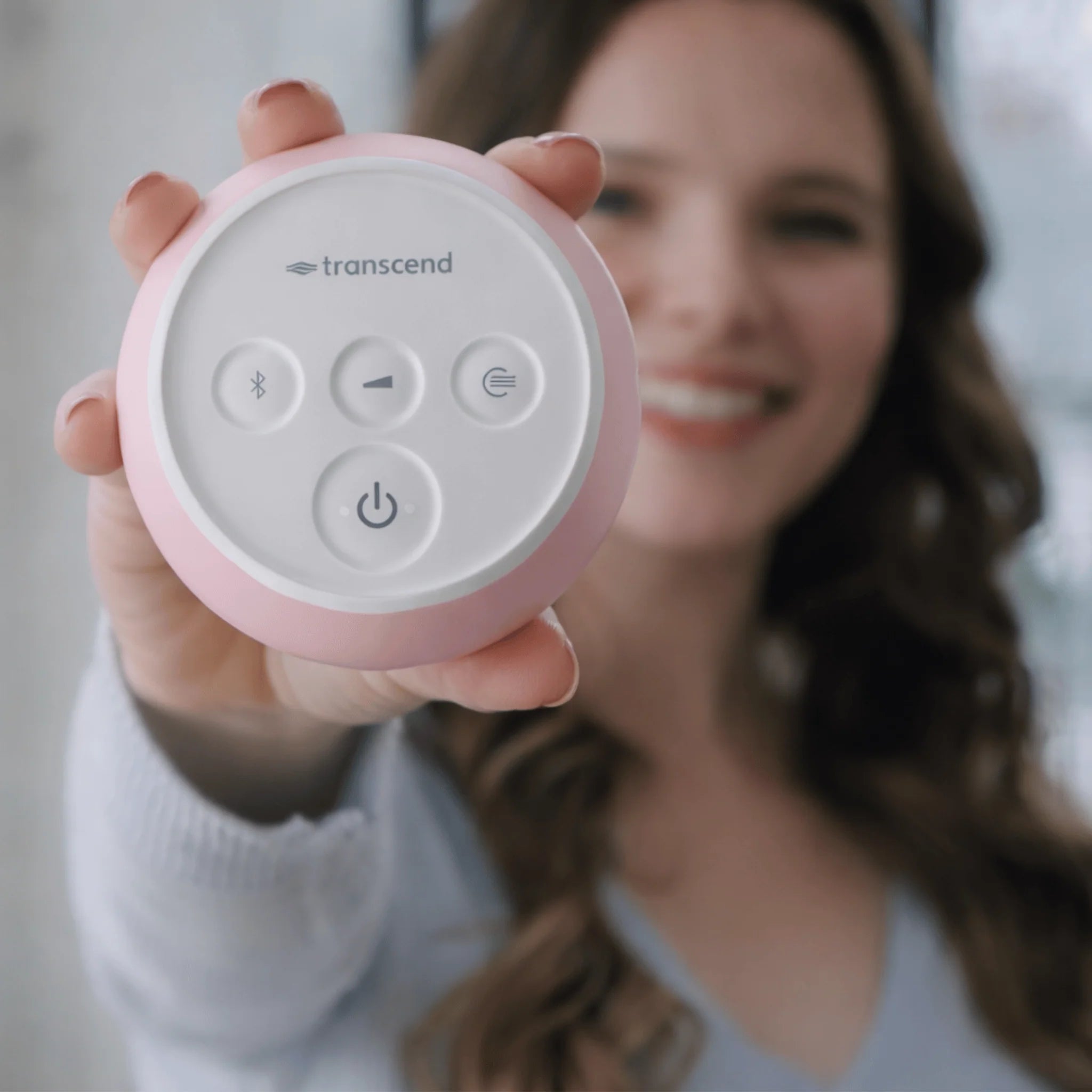 Woman holding the Transcend Micro 510 travel CPAP in petal pink, top control panel facing forward