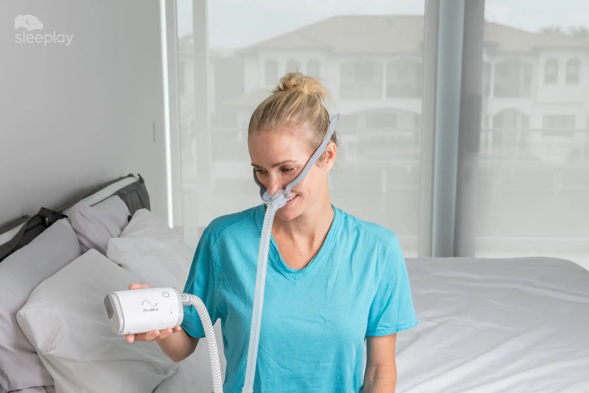 Woman showing AirMini travel CPAP.