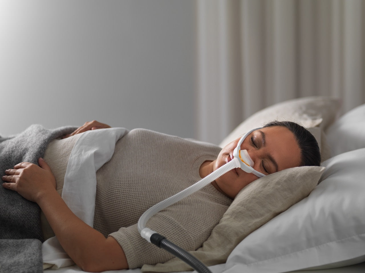 Woman using the solo pillows mask for cpap therpay