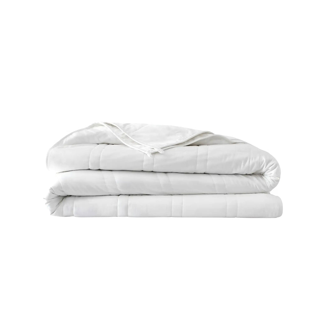 Baloo weighted cotton comforter folded in a neat white stack with quilted stitching visible