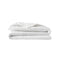 Baloo weighted cotton comforter folded in a neat white stack with quilted stitching visible