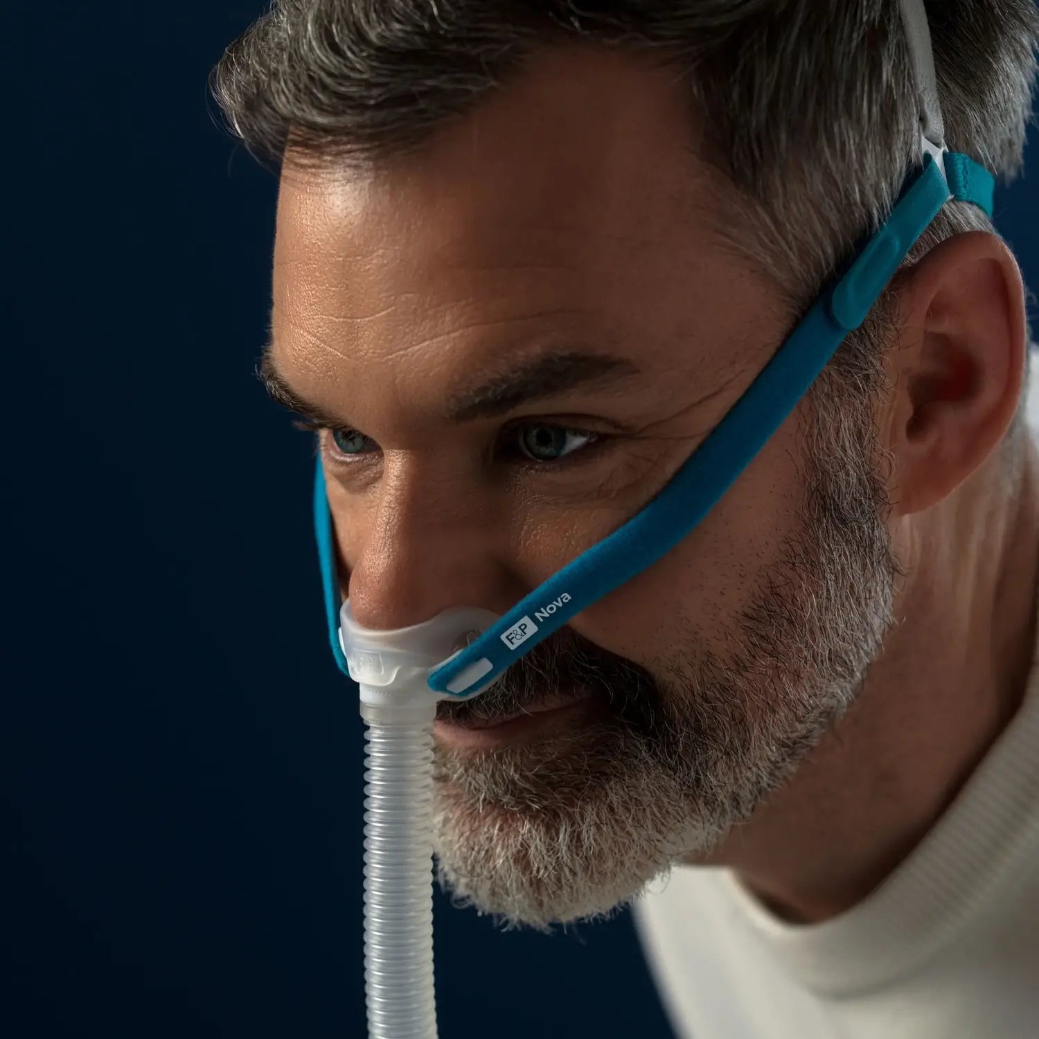 Close up to man using the F&P Nova Micro™ Nasal Pillows CPAP Mask