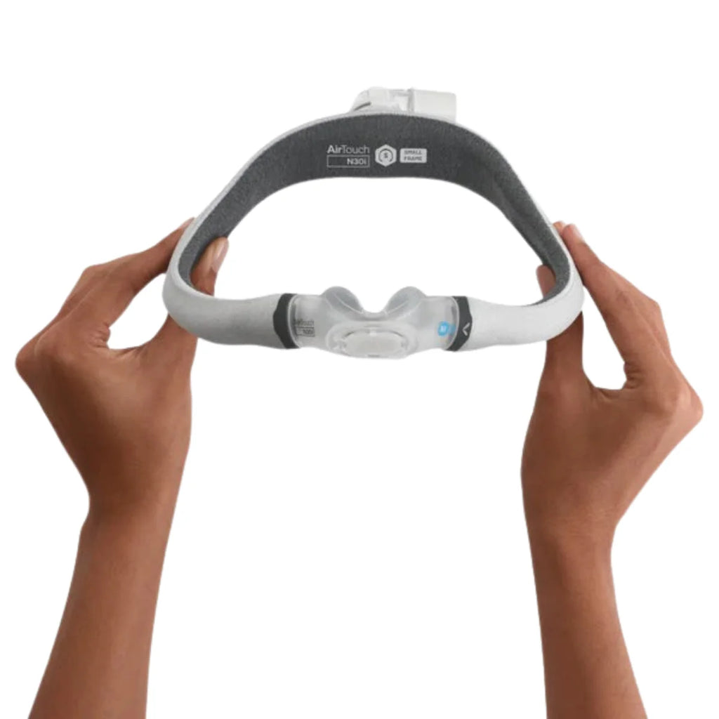 Hands holding the ResMed AirTouch N30i nasal mask without headgear