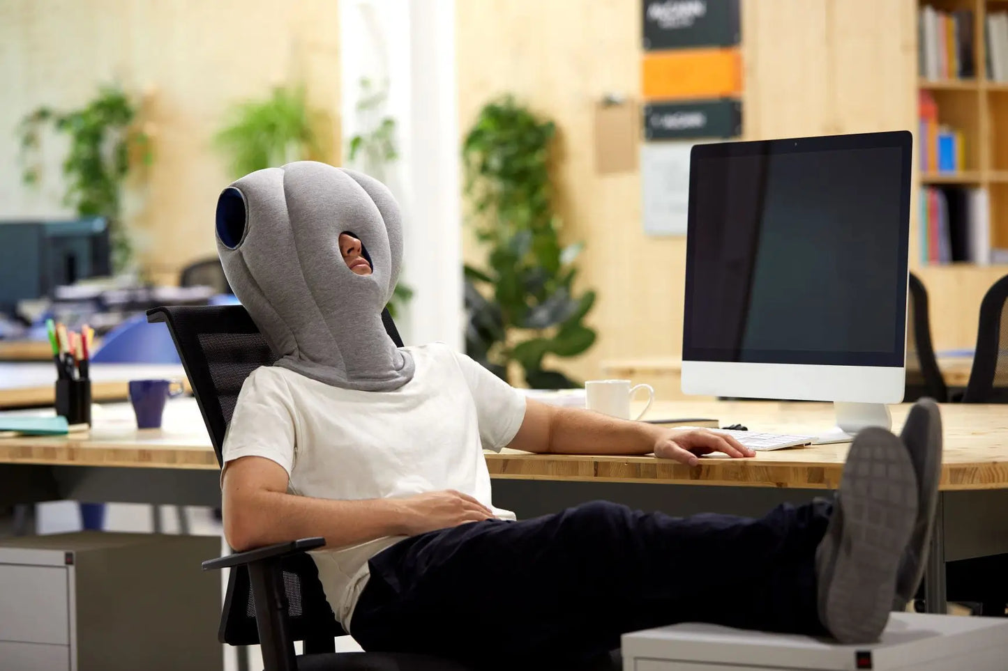 man using the Original Immersive Napping Pillow in the office