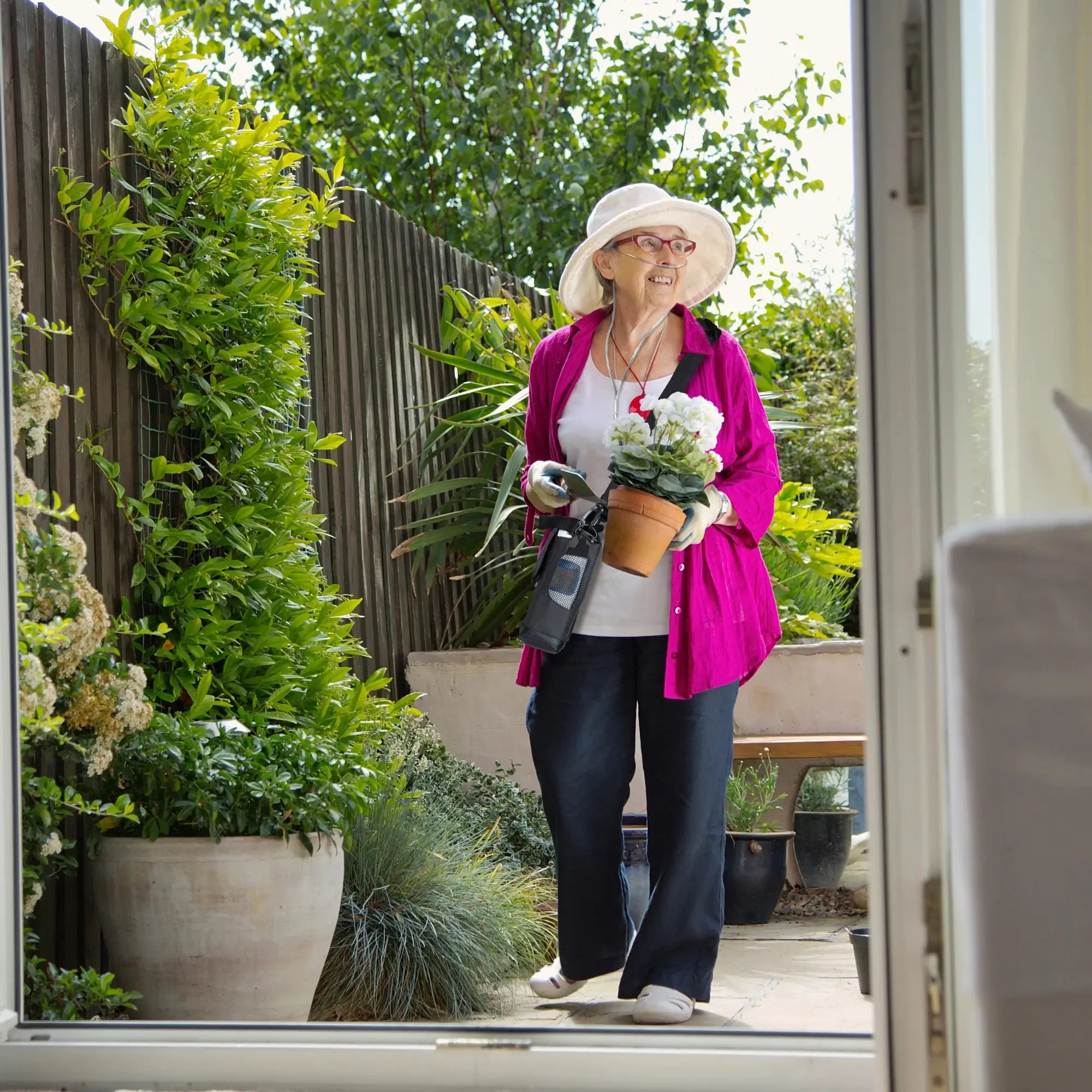 Woman using the Inogen Rove 6 Portable Oxygen Concentrator while gardening