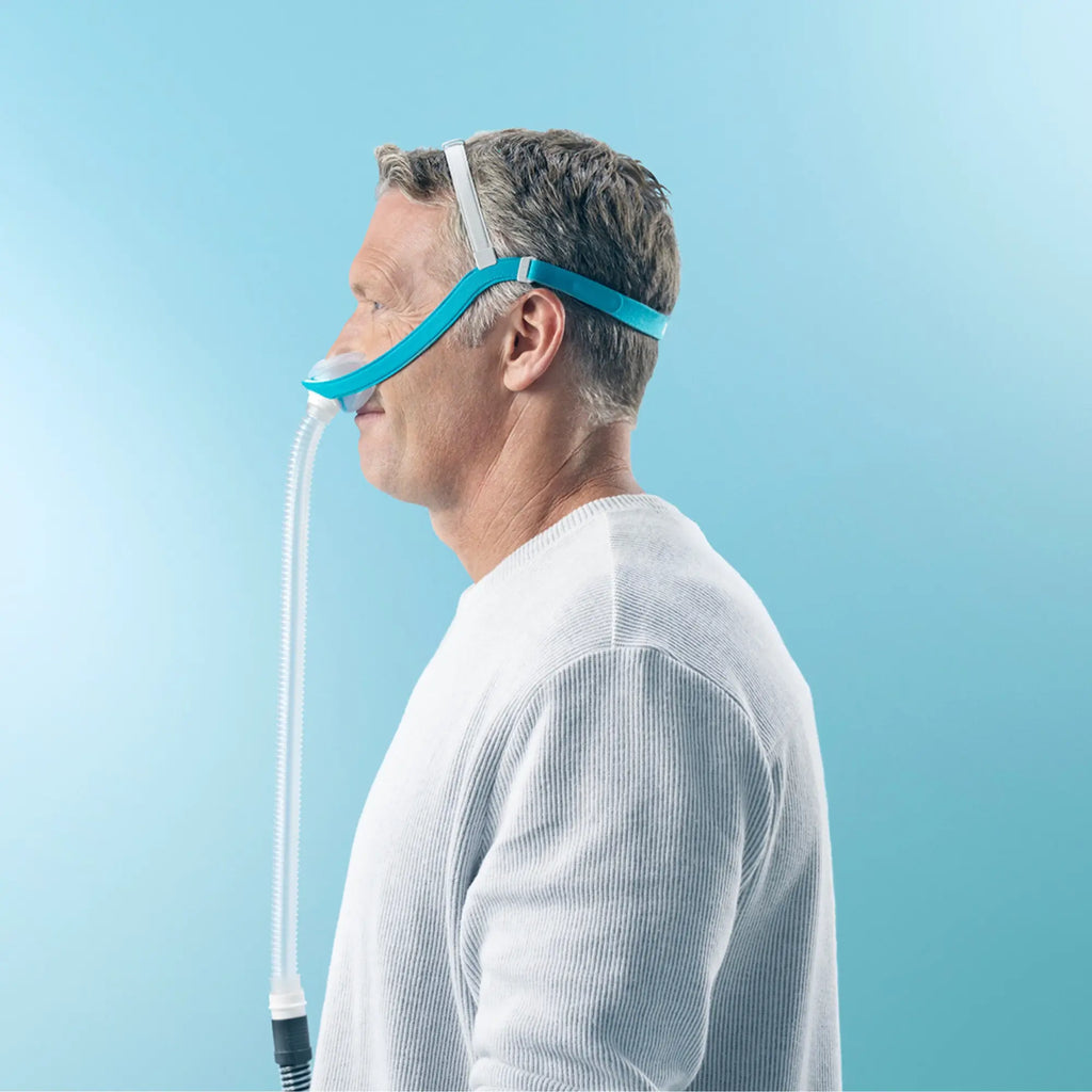 Side profile of a man wearing the Evora nasal CPAP mask, tube running down from the nasal cushion
