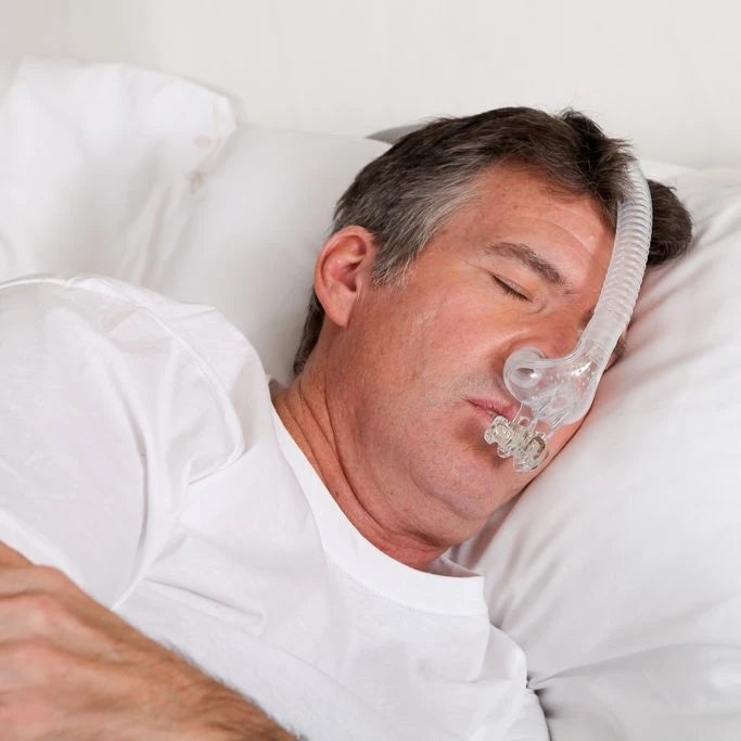 Man sleeping peacefully wearing myTAP PAP strapless CPAP mask with no straps or headgear visible