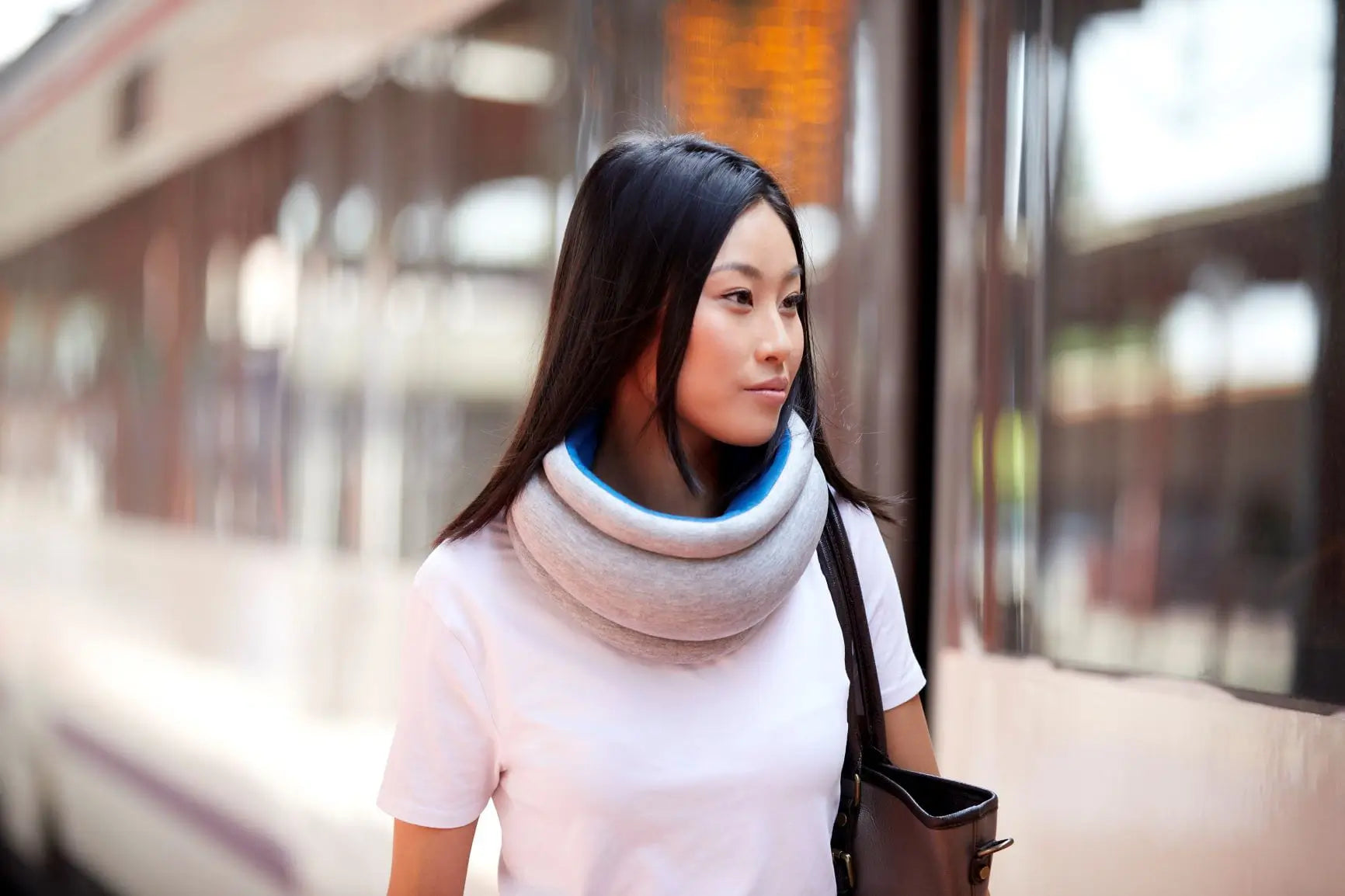 Woman using the Light Versatile Travel Pillow in the street