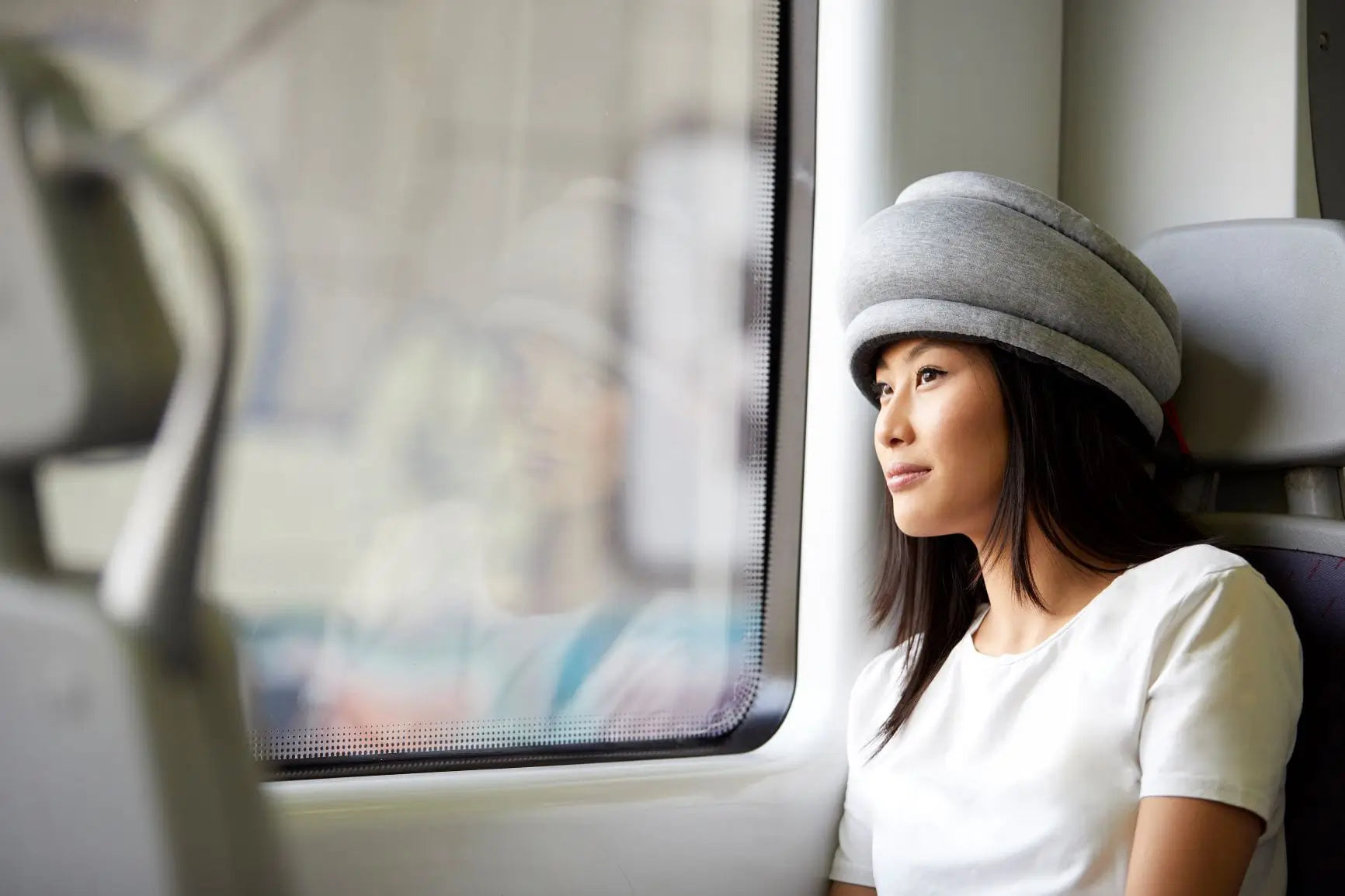 Woman using the Light Versatile Travel Pillow in the train