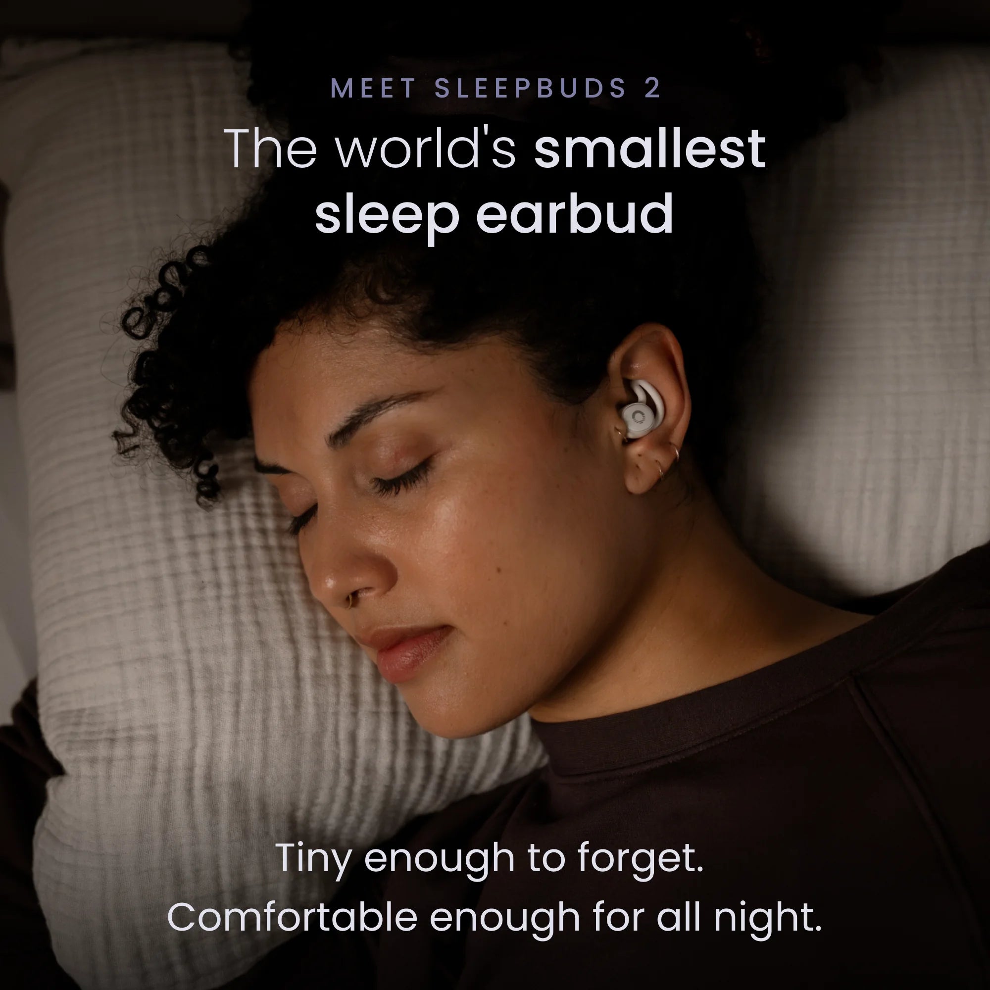 Woman sleeping on her side wearing tiny Ozlo Sleepbuds 2 sleep earbuds flush in her ear