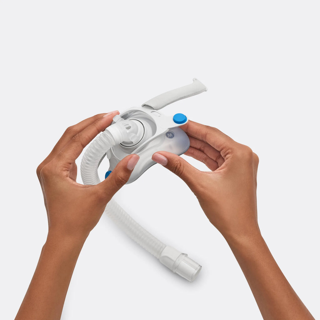 Hands holding the ResMed AirTouch F40 frame system, medium, with tube attached