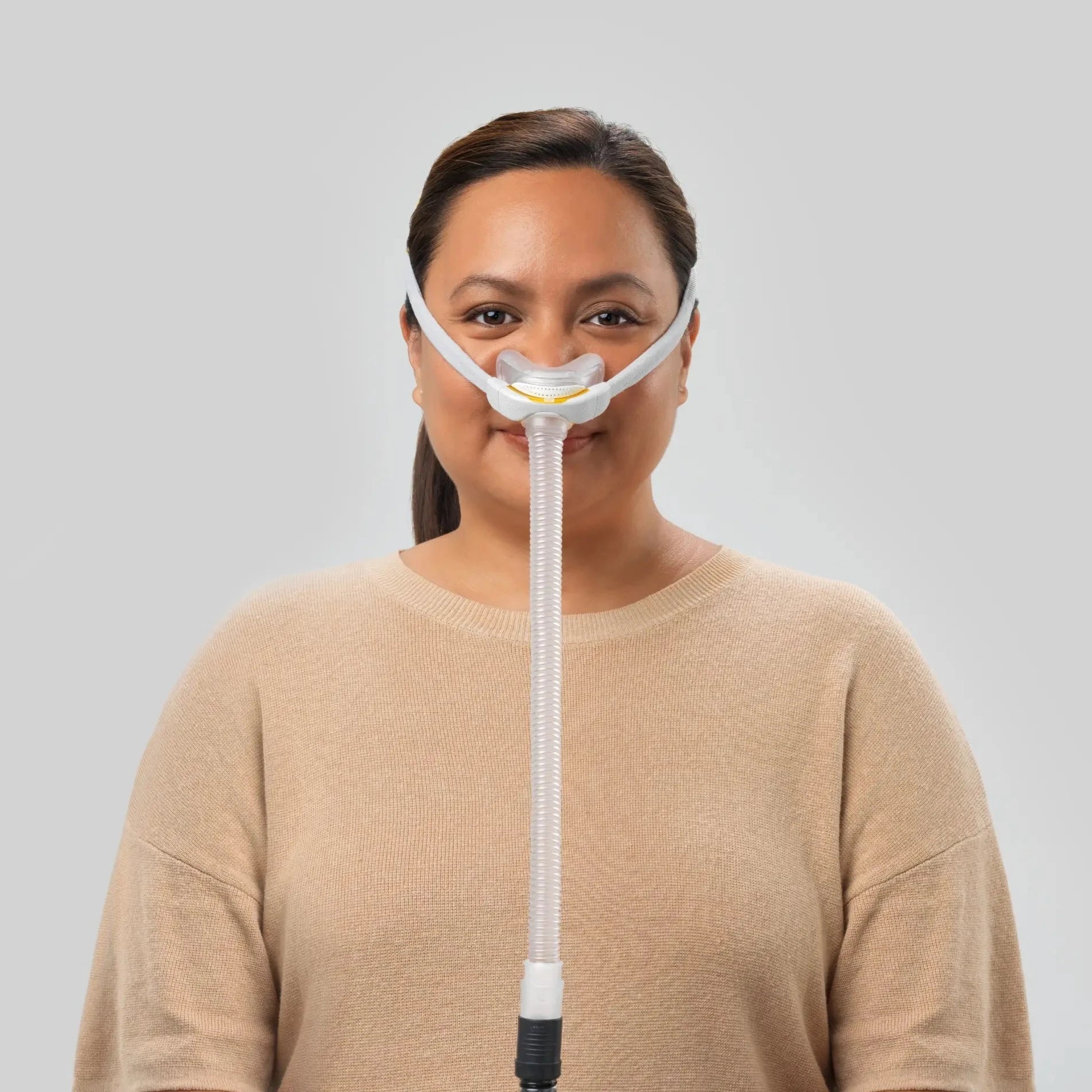 Woman using the F&P Solo Nasal CPAP Mask Autofit front view