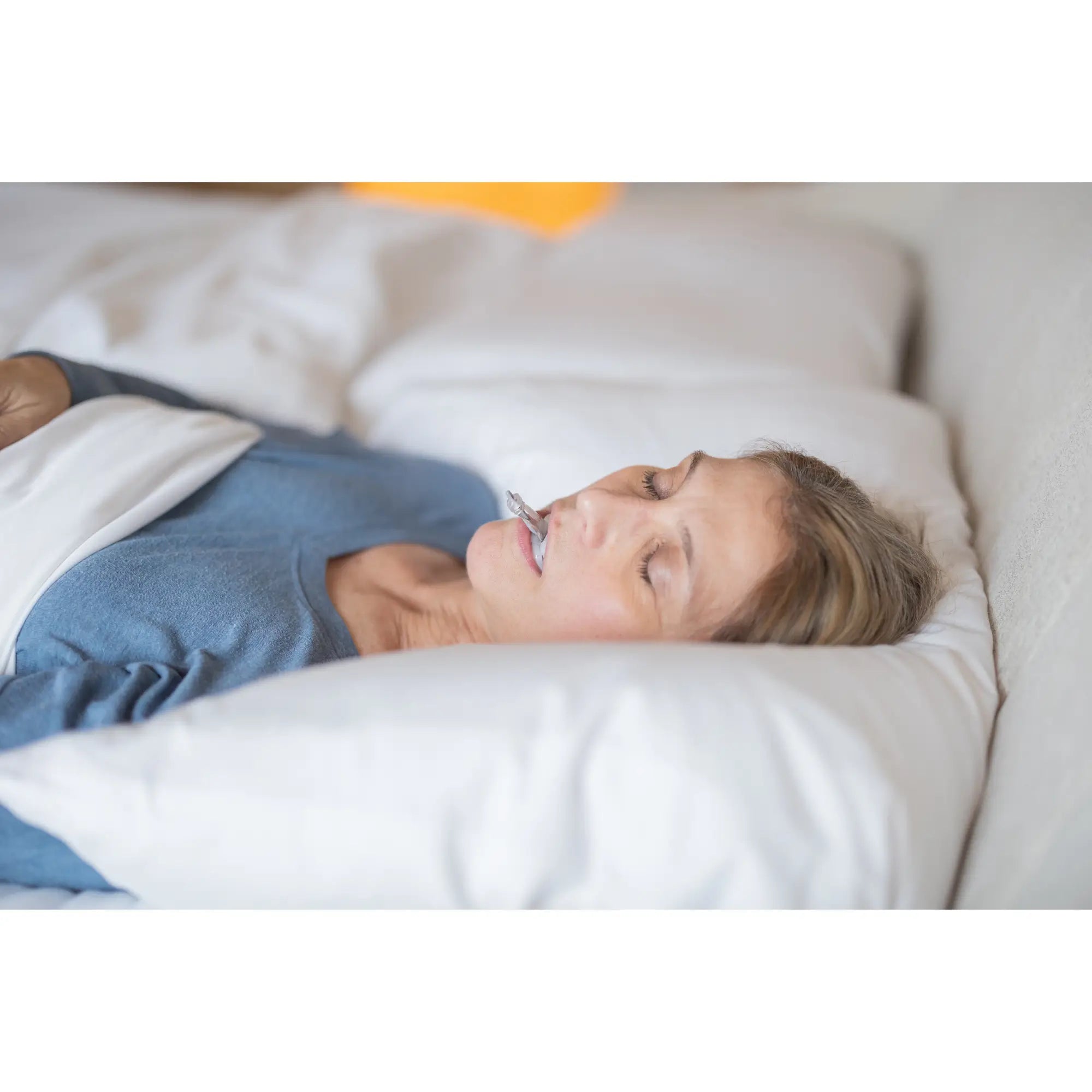 woman using the myTAP Oral Appliance in bed for snoring