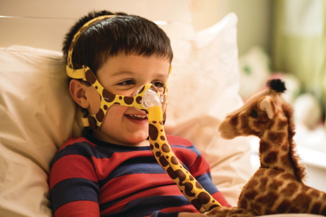 Boy smiling while using Wisp Pediatric Nasal Mask