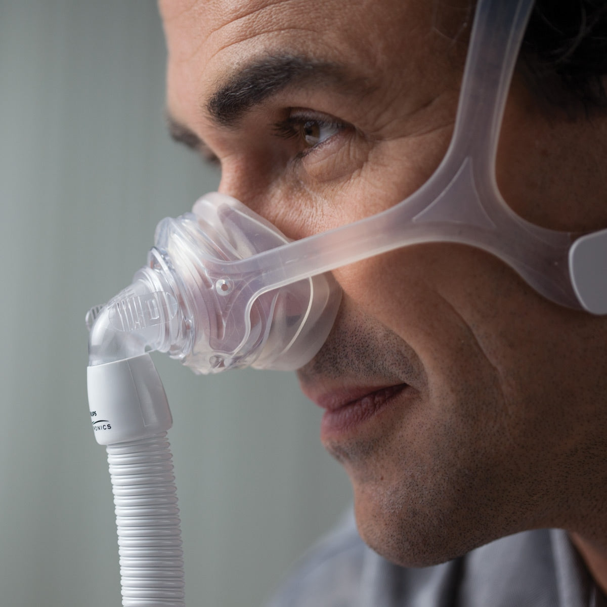 Closeup of man using the Philips Respironics Wisp Mask.