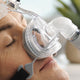 Closeup view of man's face sleeping with clear Zest Q Premium Nasal CPAP Mask with black Headgear by Fisher & Paykel.