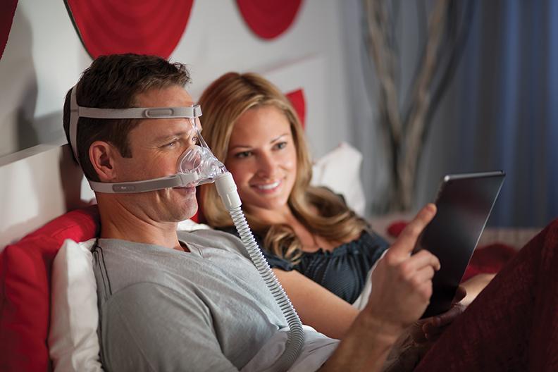 Man reading tablet while wearing the Nasal Pico Mask.