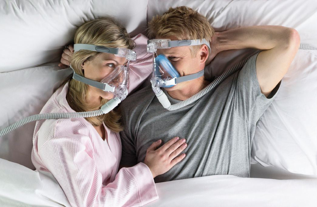 Couple laying in bed with both using the Amara Full Face CPAP Mask with Gel & Silicone Cushions
