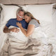 Man sleeping with ResMed AirFit P30 and his partner on the side