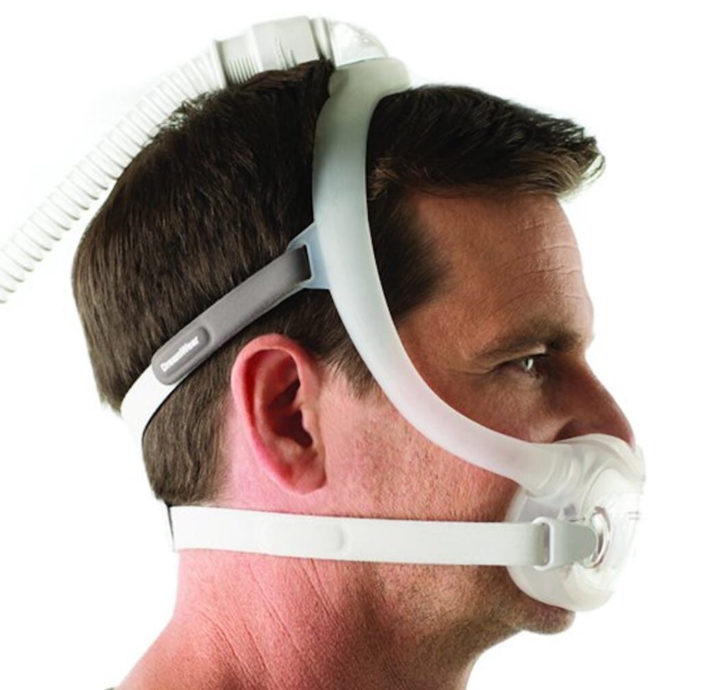 Side profile of man wearing DreamWear full face mask with headgear and top of the head tubing