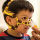 Hand adjusting boy's Wisp Pediatric Nasal Mask with giraffe print.