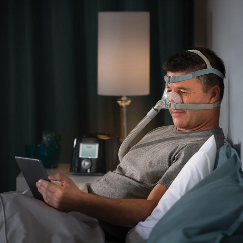 Man reading from his tablet while wearing Eson 2 Mask and headgear.