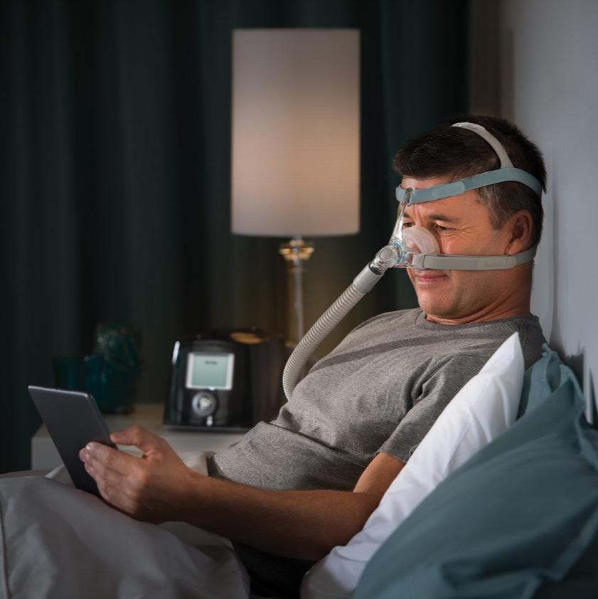 Man reading from his tablet while wearing Eson 2 Mask and headgear.