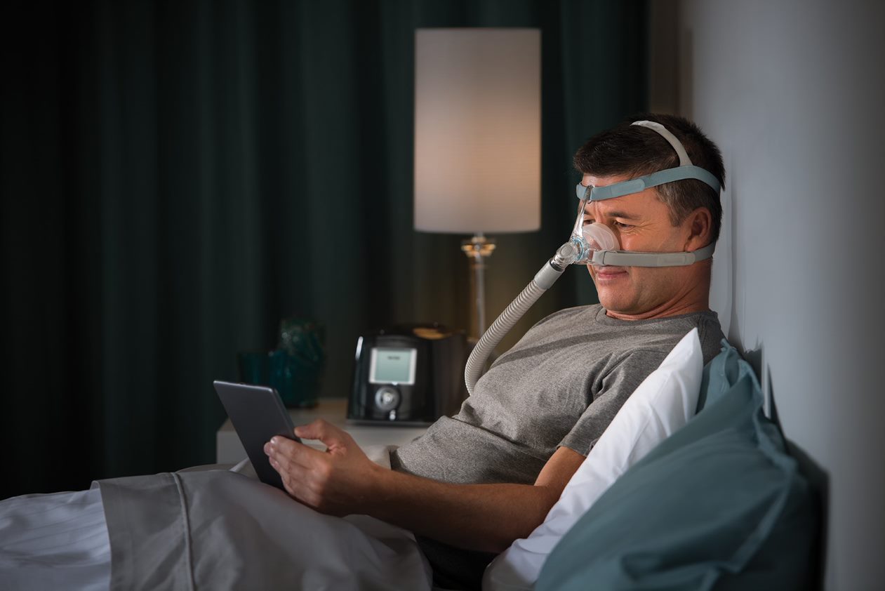 Man reading from his tablet while wearing Eson 2 Mask and headgear.