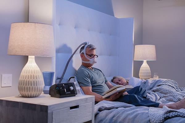 Man reading in bed with the F30i Standard System.