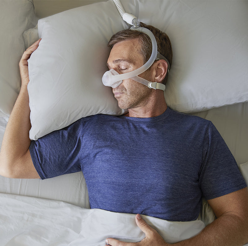 Man comfortably using DreamWisp Nasal Mask while sleeping.