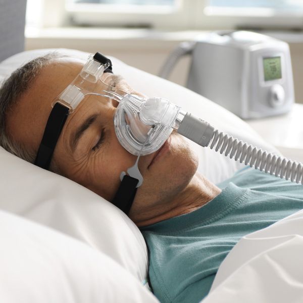 Man sleeping with clear Zest Premium Nasal CPAP Mask with black Headgear by Fisher & Paykel.