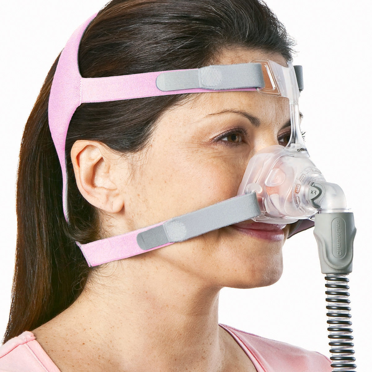 Woman wearing ResMed Mirage FX for Her nasal CPAP mask with pink headgear, side profile