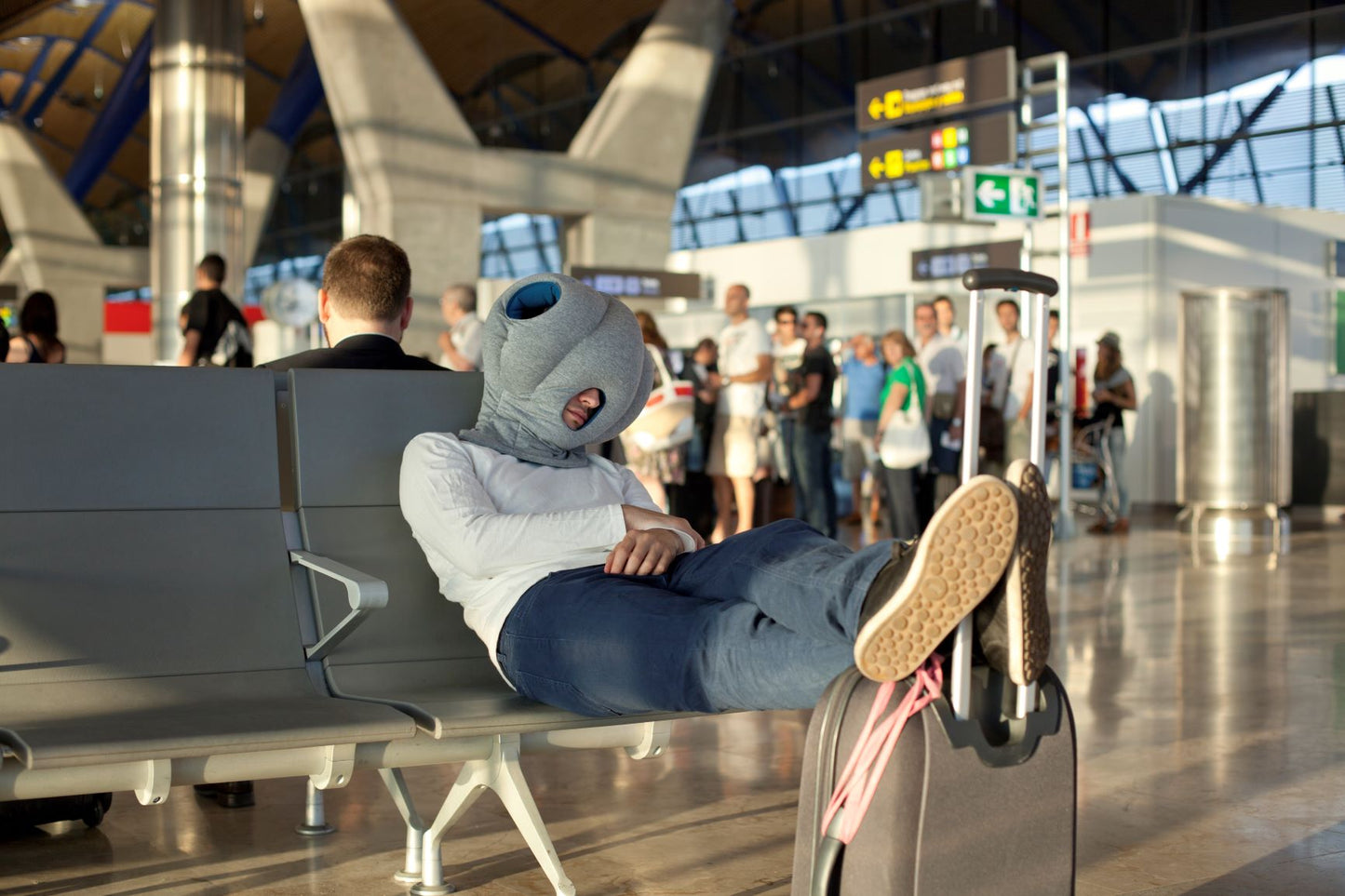 Man Sleeping In Airport With Original Immersive Napping Pillow.