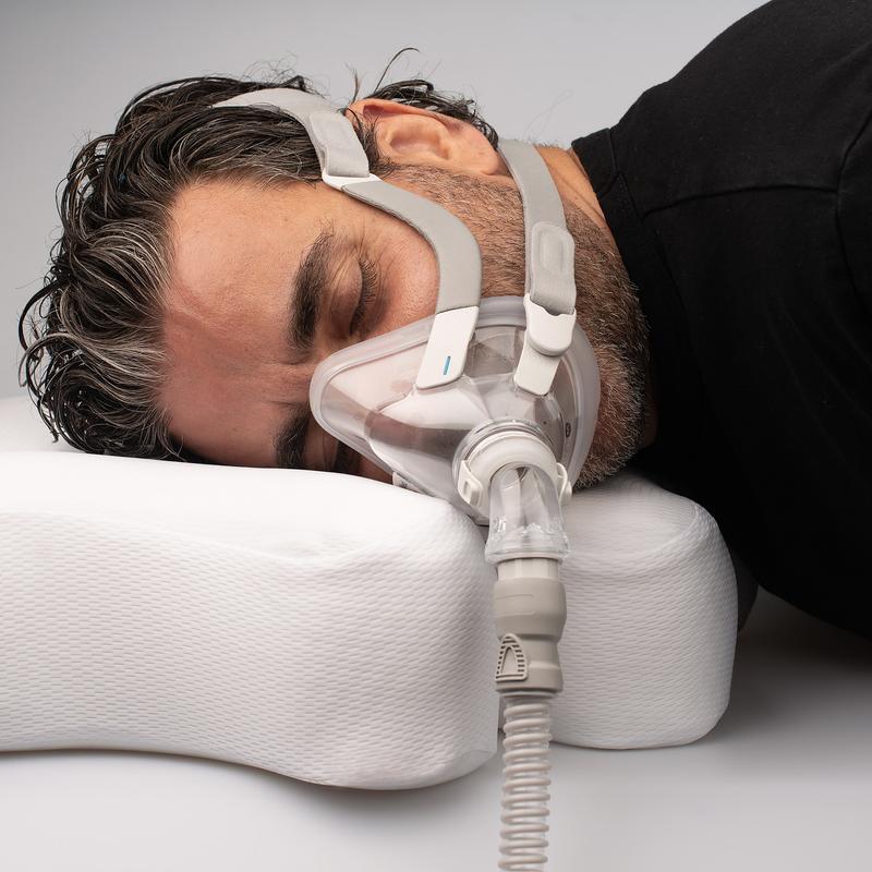 Man sleeping on his side with the pillow.