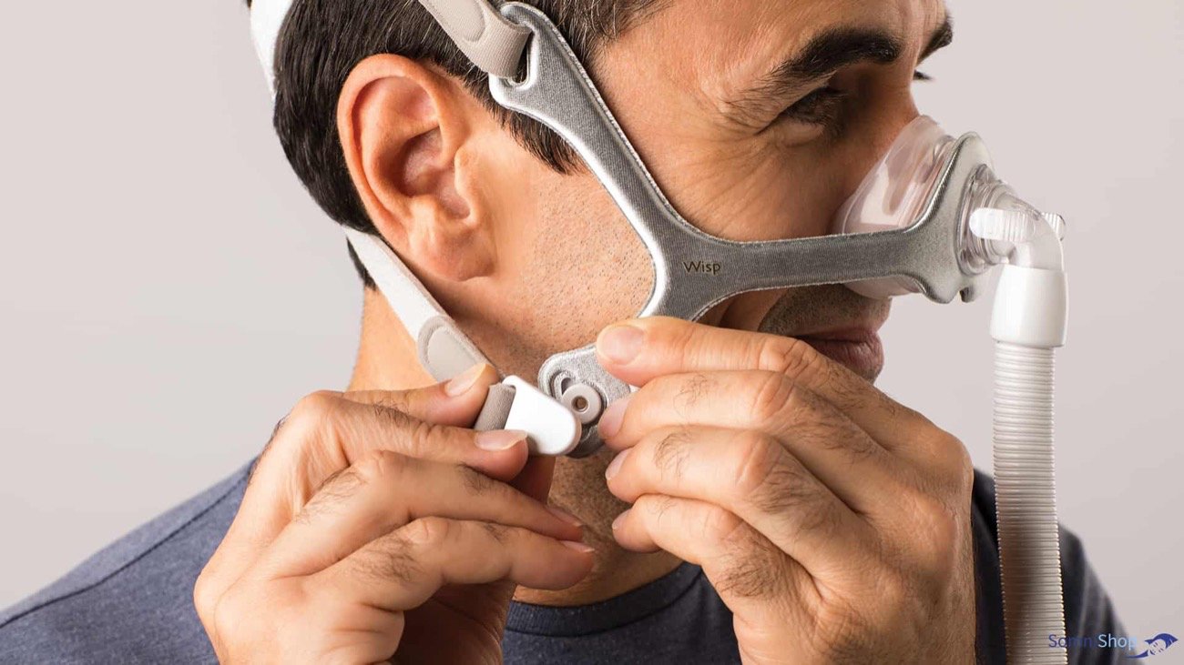 Man adjusting the Wisp Nasal Pillow Mask.