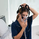 Woman putting on CPAP mask.